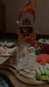 در نور آفتاب دختری که صبح با ذوق درست کردن صبحانه ای خوشمزه با چای 